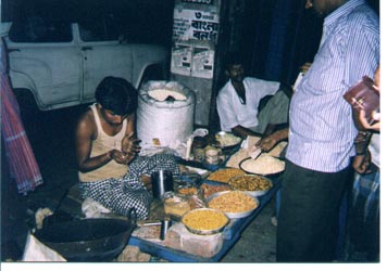 A guy selling peanuts, rosted garbanzos, puffed rice (usually stirring it all together with some spices in a tin can) on the street and then serving it in rolled up newspaper cuttings